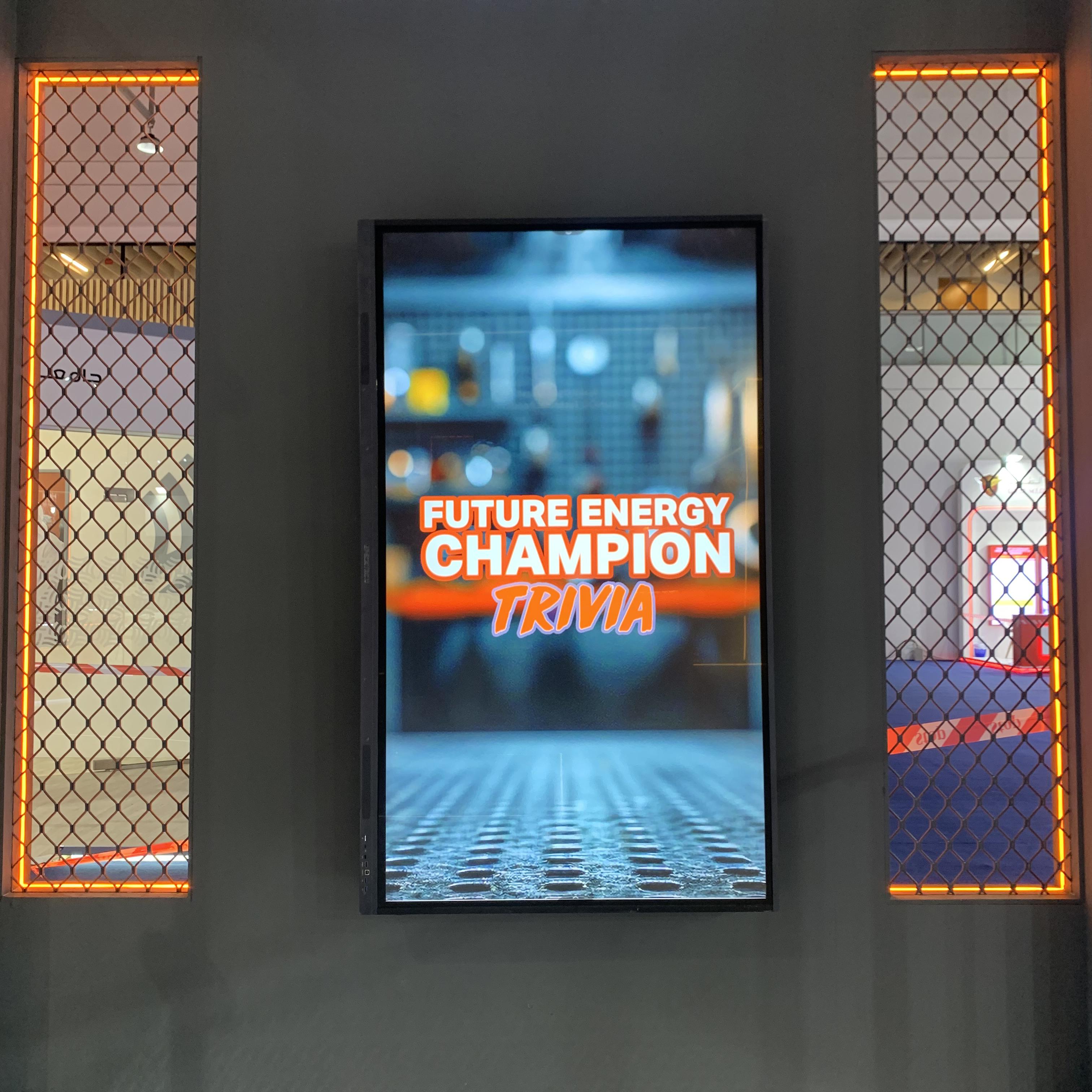 Students and guests play the Plinko Trivia Challenge at the ADNOC Technical Academy booth during a busy Dubai event